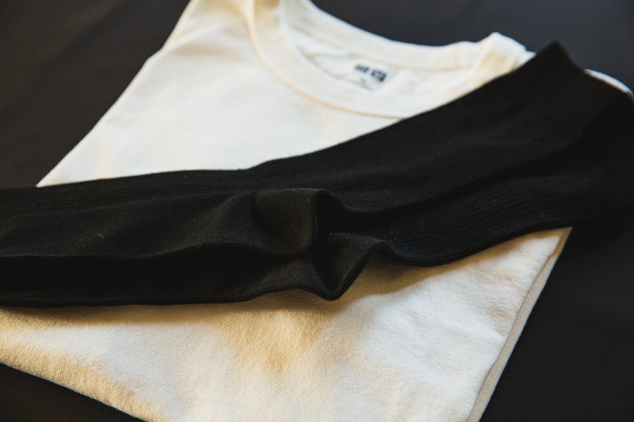From above of new white folded cotton wear with pair of black socks for man