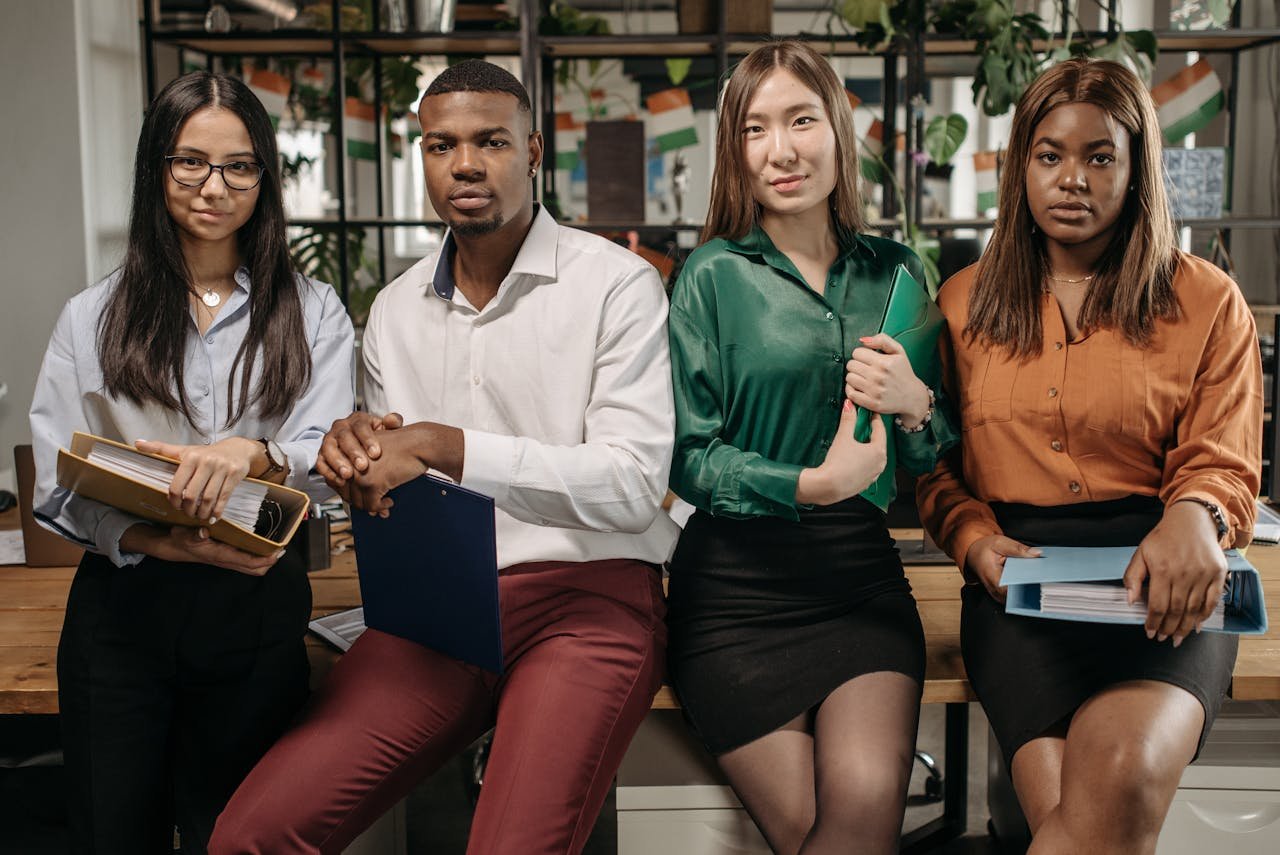 Offerings A diverse group of young professionals posing confidently in an office environment.